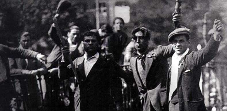 Un grupo de hombres celebra la proclamación de la II República sobre los símbolos derribados del anterior régimen dictatorial de Primo de Rivera. 