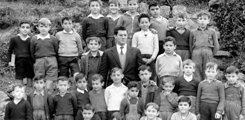 Un maestro de Avilés posa rodeado de sus alumnos durante la época.